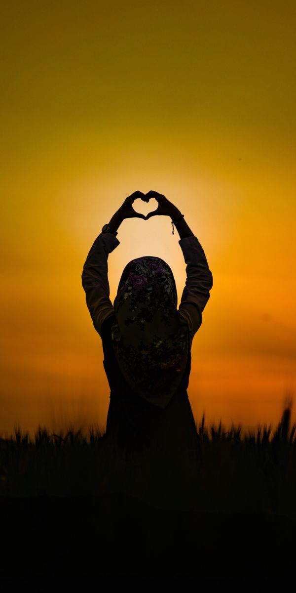 Silhouette of a Girl Holding a Heart at Sunset
