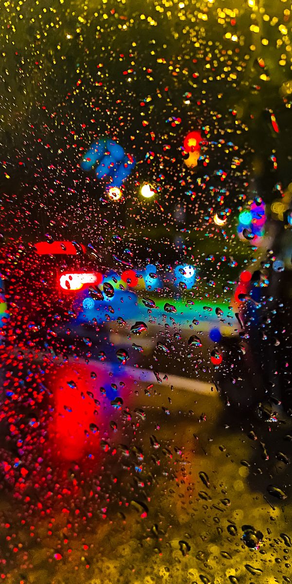 Colorful Raindrops on Glass with Vibrant Lights