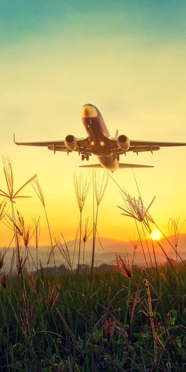 Airplane Taking Off at Sunset Over Grassland
