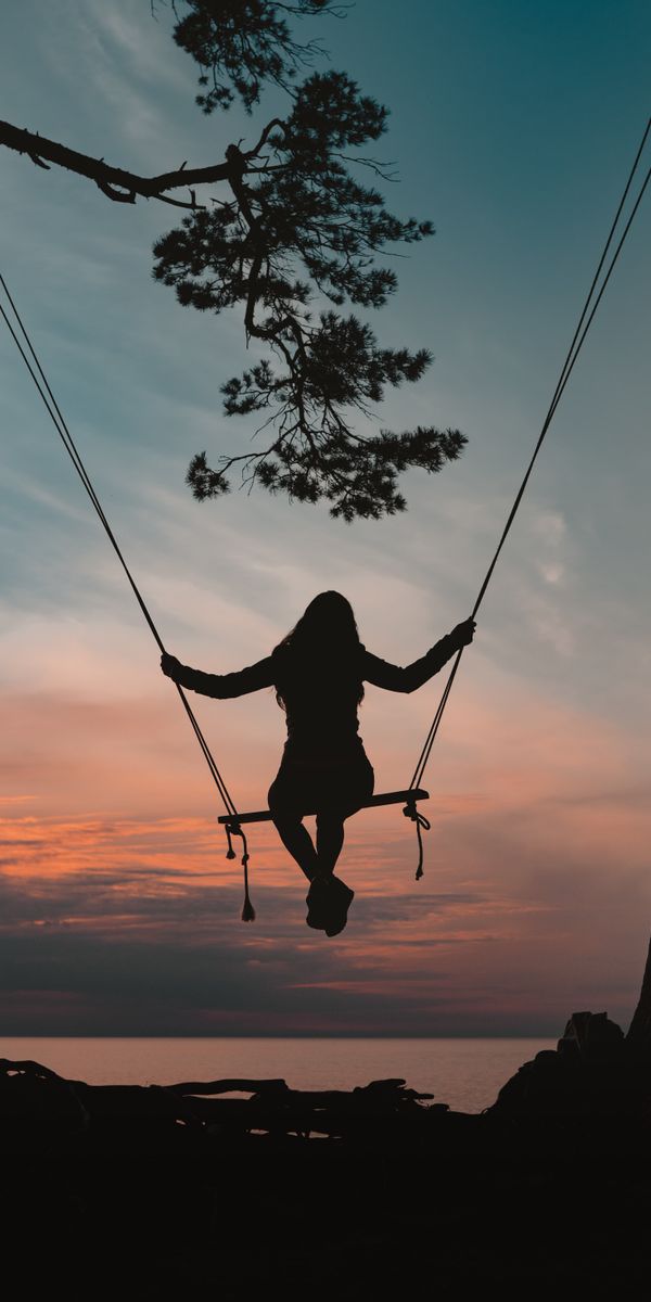 Girl Swinging Silhouette Against a Beautiful Sunset