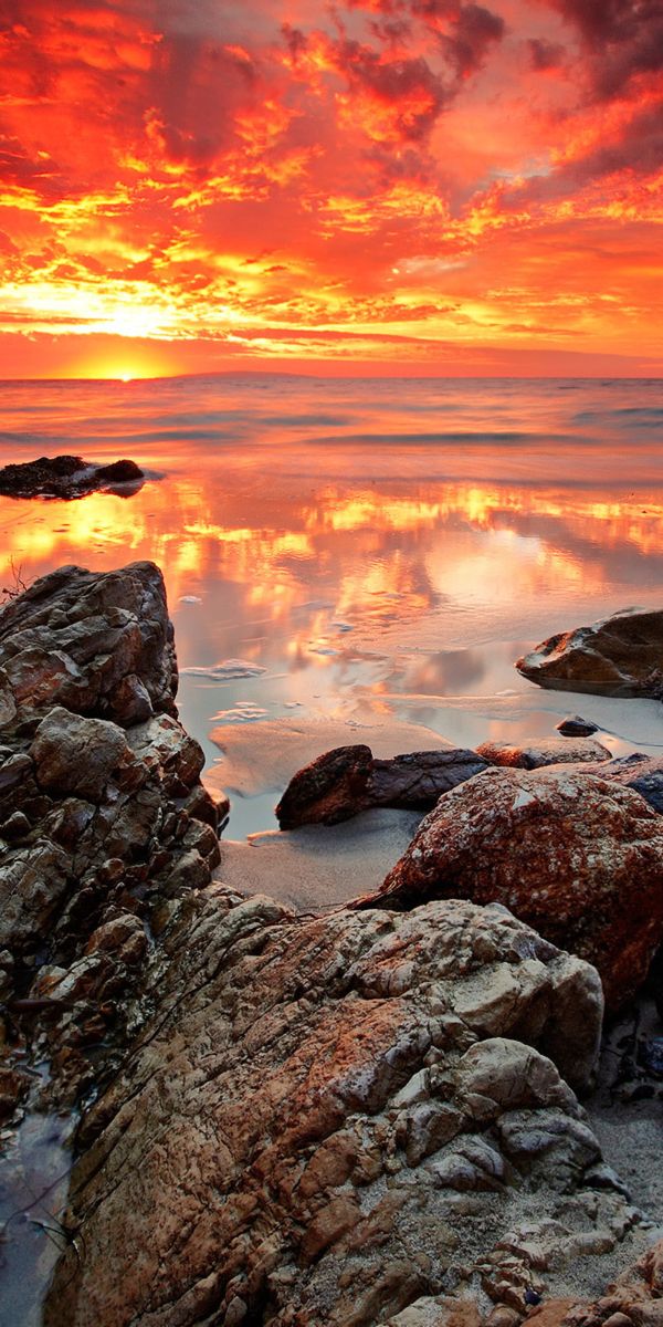 Breathtaking sunset wallpaper featuring a rocky beach and vibrant colors