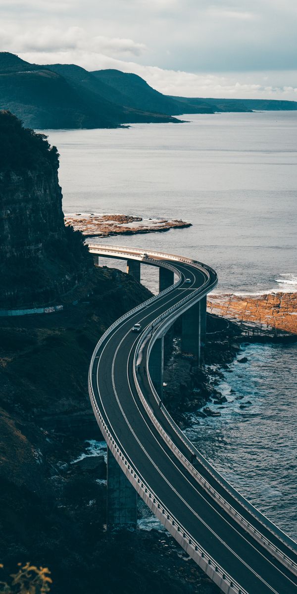 Breathtaking HD phone wallpaper of a winding coastal road by the sea