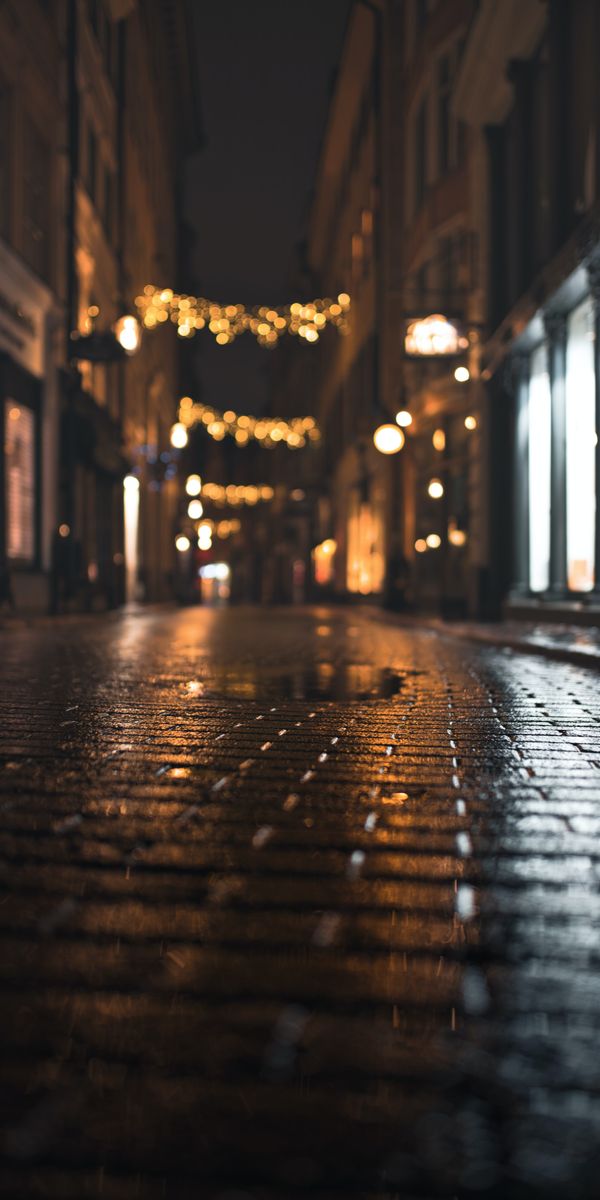 Enchanting Night Street with Wet Paving Stones and Warm Lights