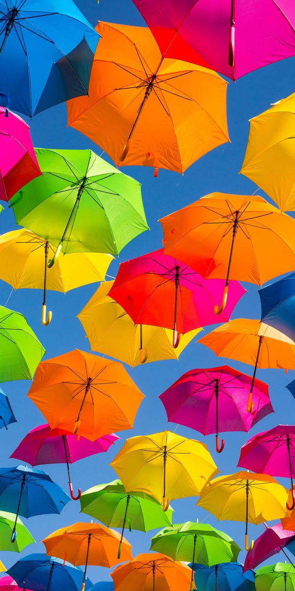 Colorful Umbrellas in a Bright Sky: A Cheerful Phone Wallpaper