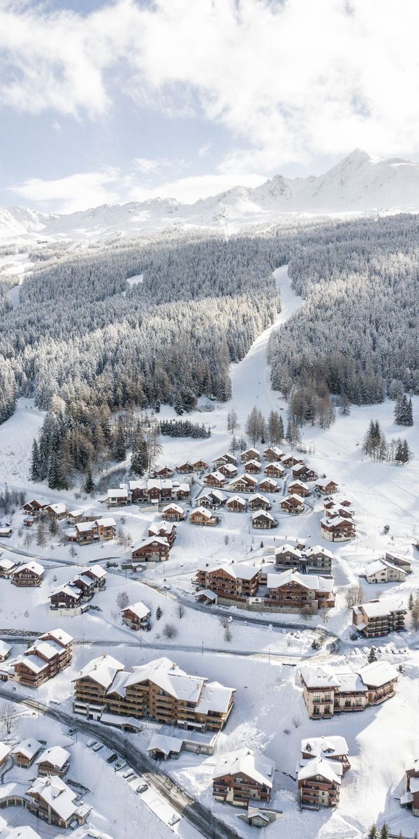 Breathtaking Winter Village Amidst Snowy Mountains