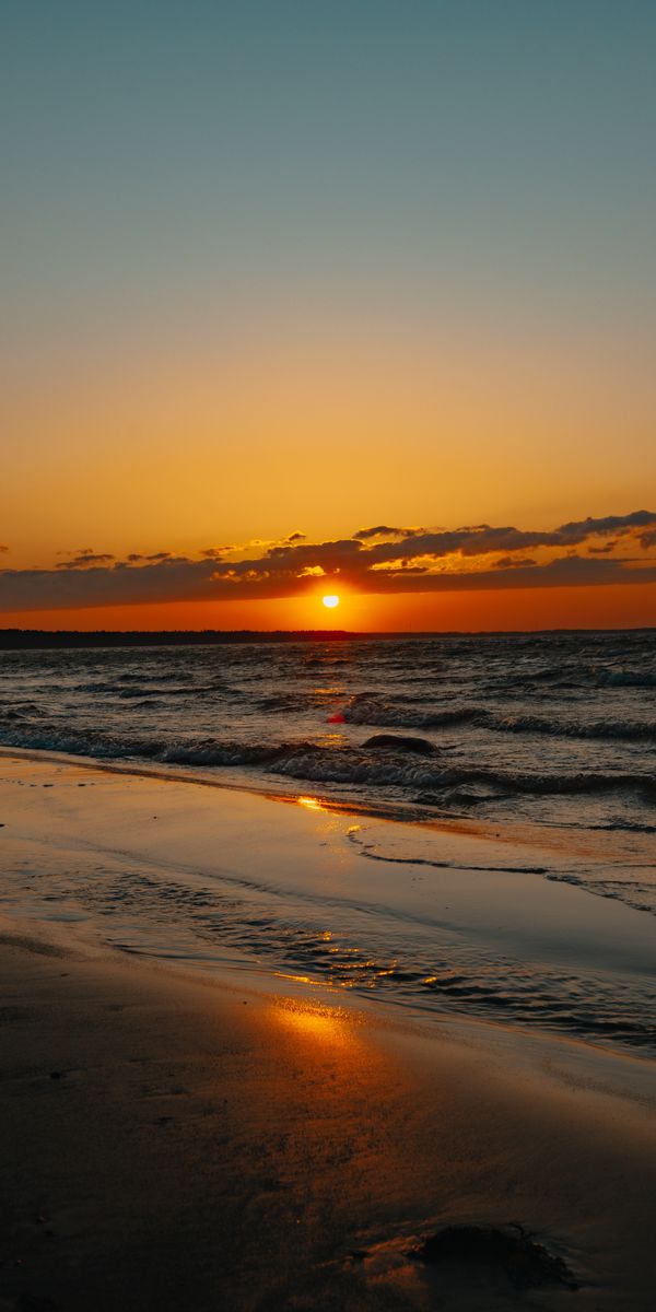 Breathtaking Sunset at the Shore with Gentle Waves