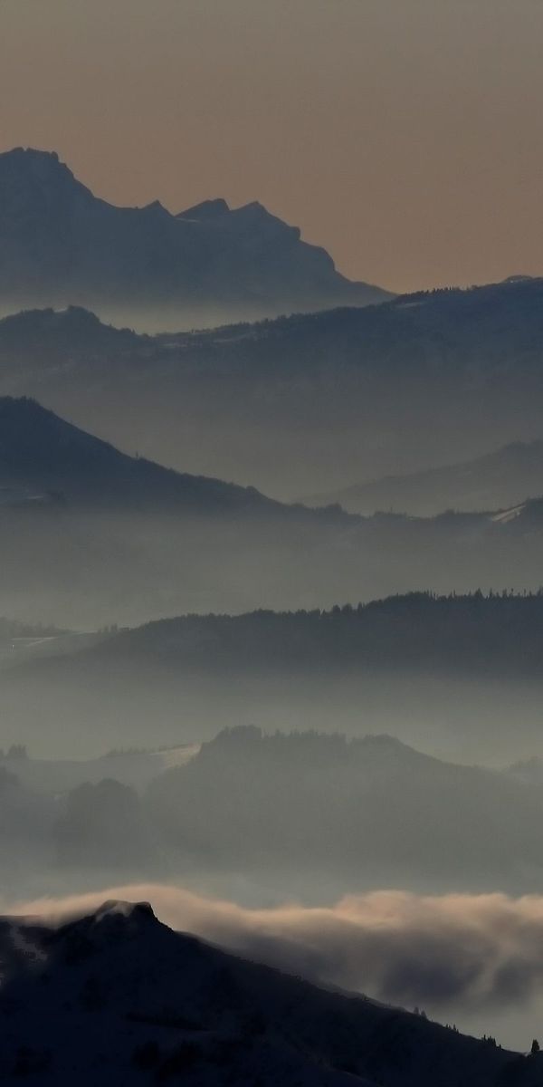 Breathtaking mountain landscape phone wallpaper featuring misty peaks