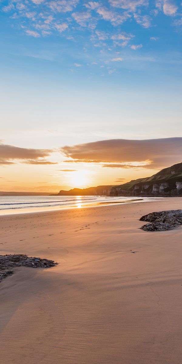 Sunset Beach Scene with Rocks and Rays of Sunlight