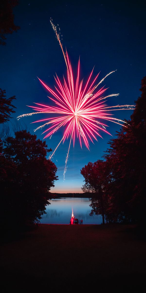 Spectacular Fireworks Over a Tranquil Lake at Night