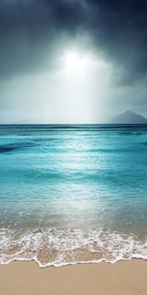Breathtaking 4K phone wallpaper of a tranquil beach landscape with sea and clouds