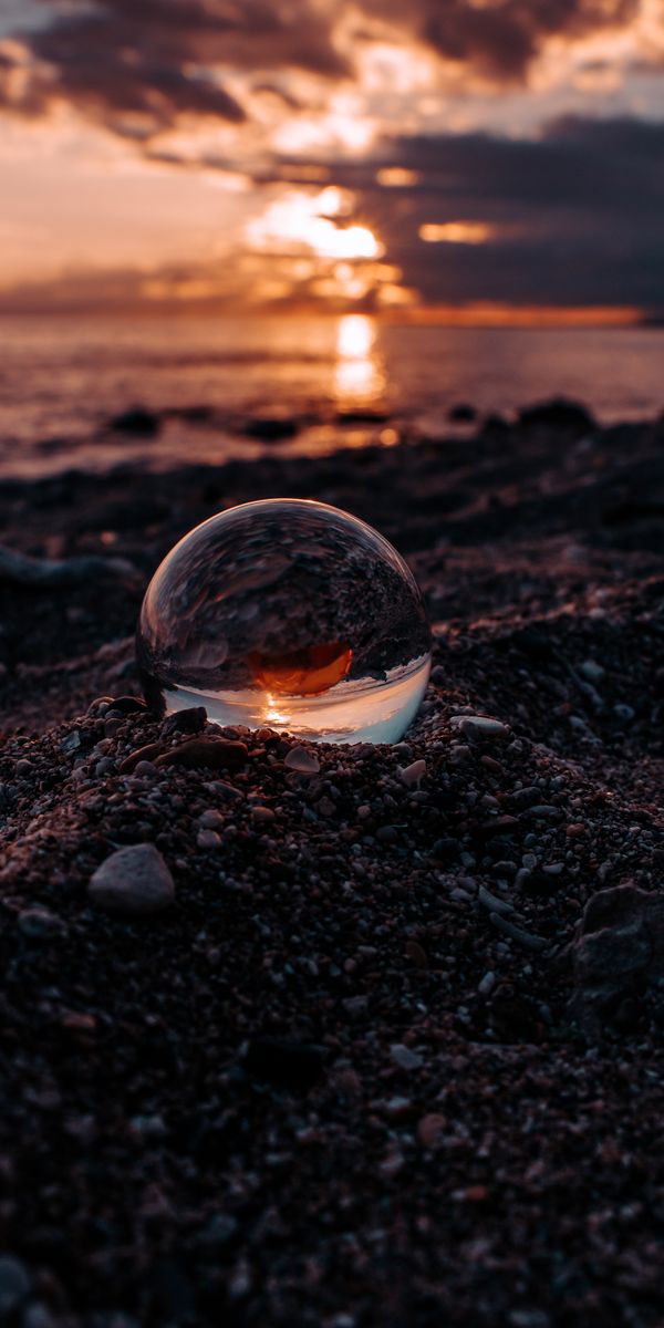 Beautiful Sunset Reflected in a Glass Ball on the Beach