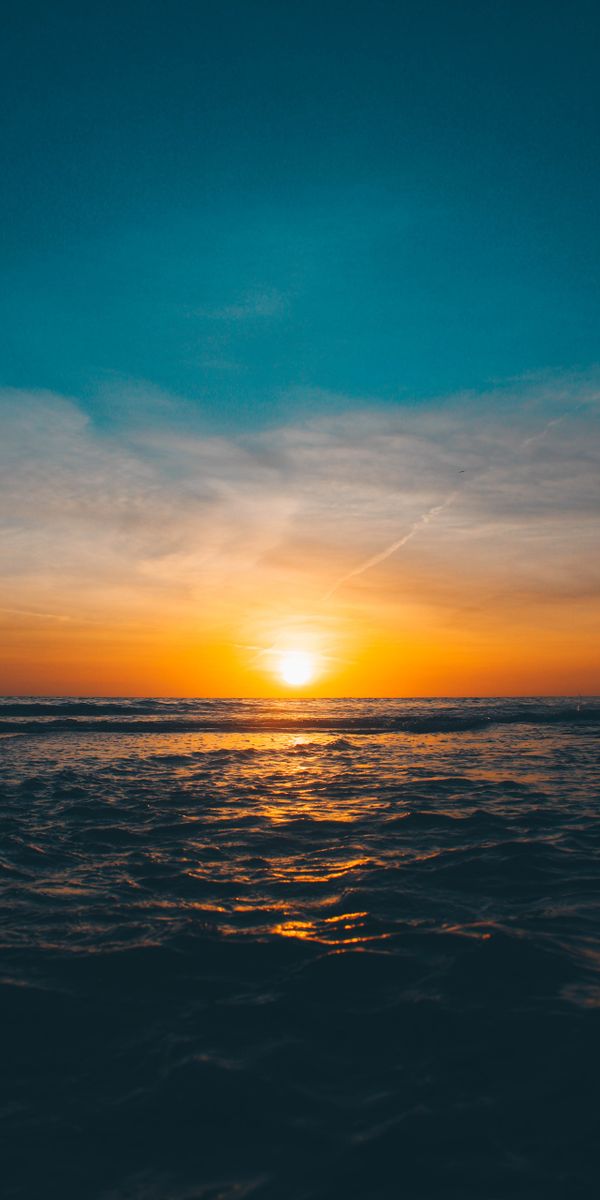 Breathtaking sunset wallpaper featuring waves and horizon for your phone
