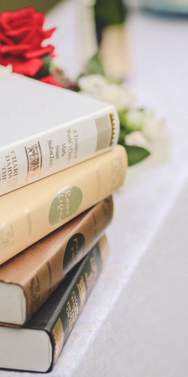 Elegant Stack of Books with Flowers for Your Mobile Wallpaper
