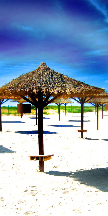 Beautiful beach wallpaper featuring thatched umbrellas and serene sands