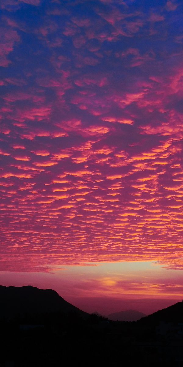 Breathtaking Sunset with Vibrant Clouds Over Hills